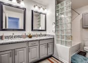 Thumbnail 5 of 39 - a bathroom with a shower and a sink and a toilet