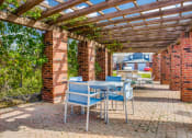 Thumbnail 12 of 39 - a patio with tables and chairs under a wooden pergola
