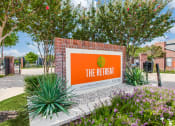 Thumbnail 39 of 39 - the retreat at thousand oaks apartments sign in front of trees and plants