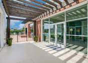 Thumbnail 23 of 39 - a covered patio with glass doors and a brick building