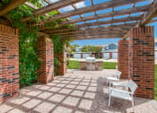 Thumbnail 13 of 39 - a patio with a pergola and a backyard with a grill