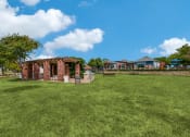 Thumbnail 35 of 39 - a brick building sits in the middle of a grassy field