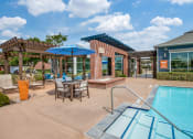 Thumbnail 9 of 39 - the preserve at ballantyne commons pool and patio with tables and umbrellas