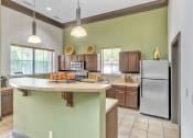 Thumbnail 25 of 35 - a kitchen with a large island and a stainless steel refrigerator