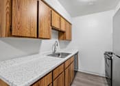 Thumbnail 11 of 26 - A kitchen with wooden cabinets and a granite countertop.