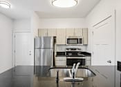 Thumbnail 14 of 17 - A kitchen with a refrigerator, microwave, oven, and sink.