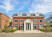 Thumbnail 1 of 39 - A red brick building with a white entrance and a sign that says "ACCOMMODATION".