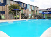 Thumbnail 33 of 36 - a large swimming pool with a building in the background