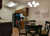 Thumbnail 3 of 8 - a kitchen and dining room with a table and chairs