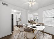Thumbnail 4 of 35 - A dining room with a white table and chairs.
