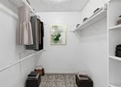 Thumbnail 11 of 35 - A small closet with a painting on the wall and a shelf with folded clothes.