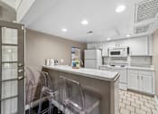 Thumbnail 32 of 35 - A kitchen with white cabinets and a white counter top.