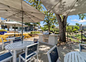 Thumbnail 20 of 35 - A patio with tables and chairs under umbrellas.