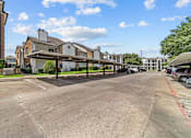 Thumbnail 12 of 18 - A parking lot with a building in the background.
