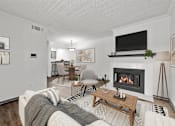 Thumbnail 1 of 18 - A living room with a fireplace and a couch.