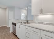 Thumbnail 11 of 17 - an empty kitchen with white cabinets and a sink