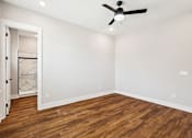 Thumbnail 34 of 38 - A room with a ceiling fan and wooden flooring.