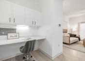 Thumbnail 14 of 35 - a home office with white cabinets and a desk with a chair