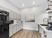 Thumbnail 23 of 32 - a kitchen with white cabinets and black appliances and a black refrigerator