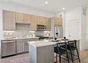Thumbnail 10 of 26 - A modern kitchen with a white countertop and wooden cabinets.