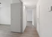 Thumbnail 18 of 38 - A room with a grey door and a wooden floor.