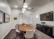 Thumbnail 9 of 17 - a meeting room with a table and chairs and a tv on the wall