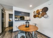 Thumbnail 3 of 40 - a dining area with a table and chairs and a kitchen in the background