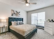 Thumbnail 24 of 40 - a bedroom with a bed and a ceiling fan