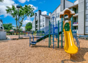 Thumbnail 33 of 40 - a playground with a yellow slide and blue playset in front of apartments