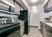 Thumbnail 1 of 40 - an apartment kitchen with black appliances and white counters