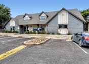 Thumbnail 18 of 33 - a house with a parking lot and a car in front of it