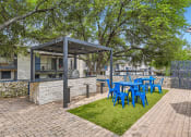 Thumbnail 29 of 33 - a patio with a blue table and chairs and a grill