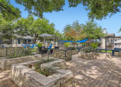 Thumbnail 27 of 33 - a patio with stone walls and trees and a fountain