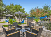 Thumbnail 12 of 33 - a patio with chairs and umbrellas and a hammock