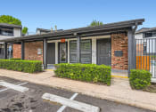Thumbnail 33 of 33 - a small brick building with a gray door and a sidewalk