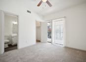 Thumbnail 8 of 33 - an empty living room with a sliding glass door to a bathroom