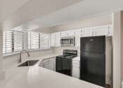 Thumbnail 1 of 33 - an empty kitchen with black appliances and white cabinets