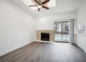 Thumbnail 6 of 33 - an empty living room with a fireplace and a ceiling fan