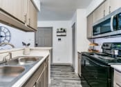 Thumbnail 2 of 30 - a kitchen with a sink and a stove and a microwave