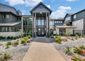 Thumbnail 29 of 30 - the front entrance of a house with a gravel pathway and plants