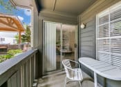 Thumbnail 12 of 30 - a balcony with a table and chairs and a door to a patio