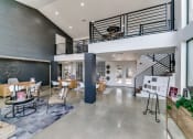 Thumbnail 15 of 30 - the lobby of a building with a staircase and tables and chairs
