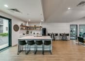 Thumbnail 16 of 29 - a kitchen and dining area with a white counter top and a table with chairs
