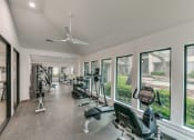 Thumbnail 12 of 29 - a gym with cardio machines and windows in a building