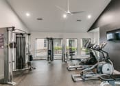 Thumbnail 13 of 29 - a home gym with exercise machines and a tv