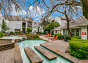 Thumbnail 22 of 29 - a swimming pool with a fountain in front of a building