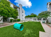 Thumbnail 25 of 29 - a backyard with a green lawn and a playground and an apartment building