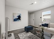 Thumbnail 2 of 22 - A living room with a blue ottoman, a white couch, and a painting on the wall.