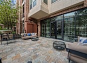 Thumbnail 25 of 33 - a patio with two couches and chairs in front of a building