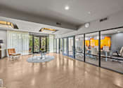 Thumbnail 16 of 33 - a large living room with glass windows and a table and chairs